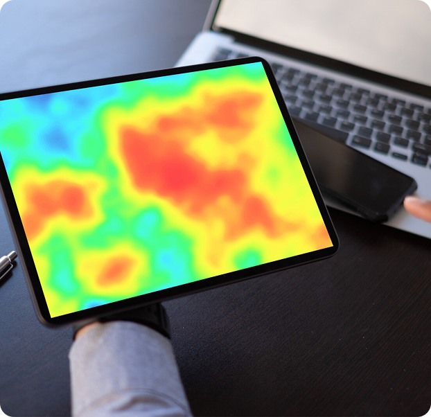 A person grasping a tablet that features a heat map